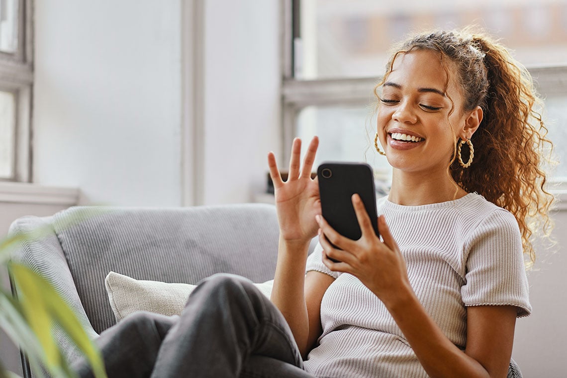 Female sitting on couch scrolling on a phone