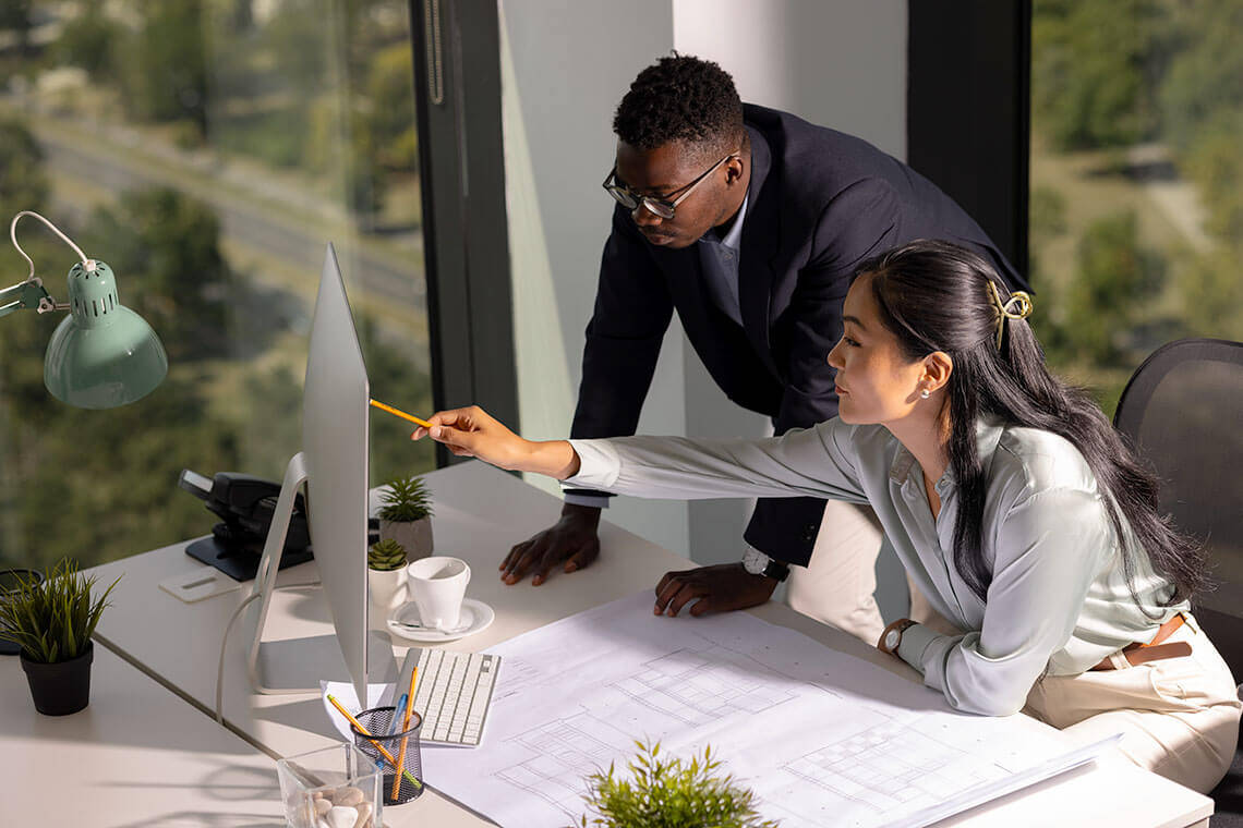 Man and a woman looking at a computer in an office